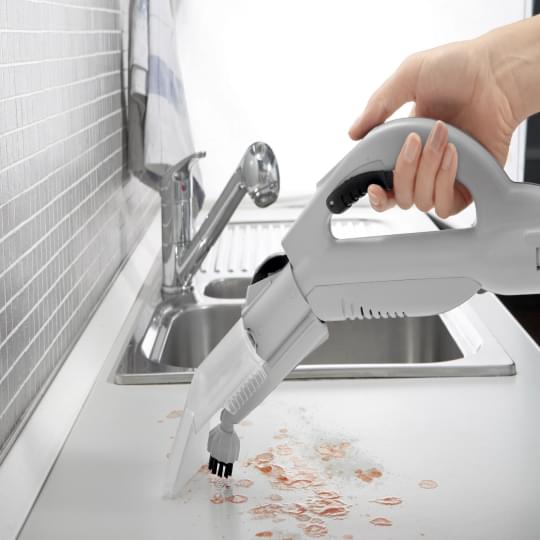 Vacuuming on the counter top near the basin